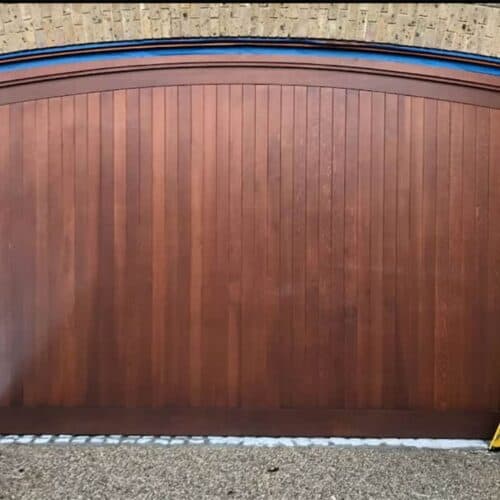 Cedar Door Custom Design Arched Top Timber Up & Over Garage Door in Walnut with Matching Curved Timber Frame